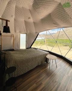 a bedroom with a bed and a large window at Eco Dom Tent in Yerevan