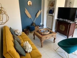 a living room with a yellow couch and a tv at SETE - 6 Quai Louis Pasteur in Sète