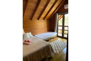a small room with a bed and a window at Morada nas Montanhas Chale 08 in Urubici