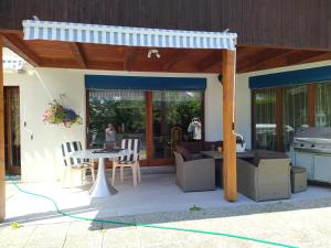 a patio with awning and a table and chairs at Chez l'Eveline in Les Bois