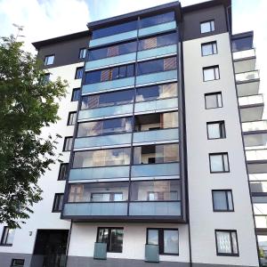 an apartment building with glass windows at Lovely new city apartment all amenities in Seinäjoki