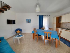 eine Küche und ein Wohnzimmer mit einem blauen Tisch und Stühlen in der Unterkunft Un Oblò sul Mare in San Lucido