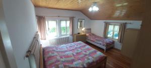 niewielka sypialnia z łóżkiem i oknem w obiekcie Casa al Lago tra le Dolomiti w mieście Pieve di Cadore