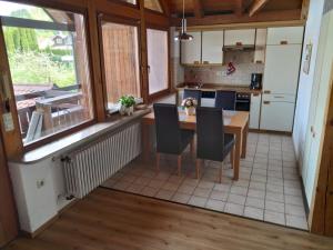een keuken met een houten tafel en stoelen in een kamer bij Ferienwohnungen Gabi Hermann in Bodman-Ludwigshafen