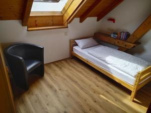1 dormitorio pequeño con 1 cama y 1 silla en Ferienwohnungen Gabi Hermann en Bodman-Ludwigshafen