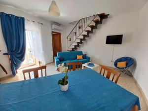ein Esszimmer mit einem blauen Tisch und einem Sofa in der Unterkunft Un Oblò sul Mare in San Lucido