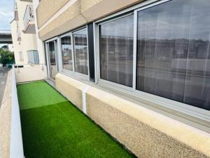 un bâtiment avec de l'herbe verte à côté d'une fenêtre dans l'établissement LORIENT EXPRESS, à Lorient