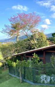 uma casa com uma árvore em frente em Studios Altos da Igrejinha em Florianópolis