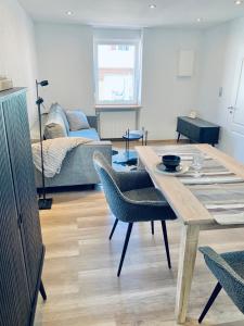 uma sala de estar com uma mesa e um sofá em Nibelungen Boardinghouse 1 Zimmer Apartment em Lindenfels