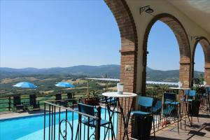 a balcony with a table and chairs next to a pool at Lo Scricciolo in Montecastelli Pisano