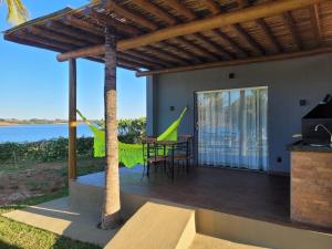 una casa con terrazza arredata con tavolo e sedie di Pousada Lago Azul a Delfinópolis