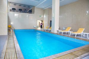 une grande piscine avec de l'eau bleue dans un immeuble dans l'établissement Hôtel FAMILLE MONDIALE, à Abidjan