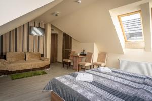 a hotel room with a bed and a couch at Osada Koszałkowo Wieżyca in Szymbark