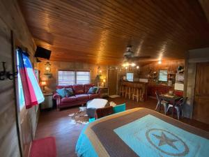 Zimmer mit einem Bett und einem Wohnzimmer in der Unterkunft 8th St. Cowboy Haus I Biker Friendly I River in Bandera