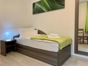 Un dormitorio con una cama con una manta verde. en Rhöner Ferienwohnung, en Stadtlengsfeld