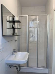 a white bathroom with a sink and a shower at Rhöner Ferienwohnung in Stadtlengsfeld