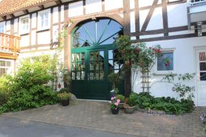 einen Eingang zu einem Gebäude mit einer grünen Tür und Pflanzen in der Unterkunft Hof Timmermann - Kuhstall in Ottenstein