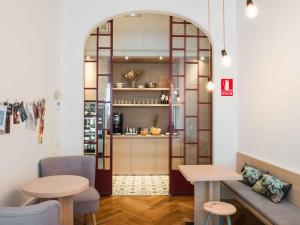 una camera con tavolo e panca e una cucina di Casa Mathilda a Barcellona