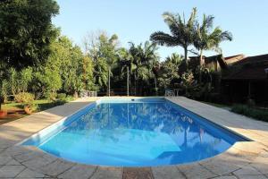 a large blue swimming pool in a yard at Hotel Cabañas Del Parque in Oberá