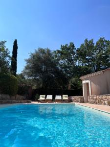 - une piscine avec 2 chaises longues à côté dans l'établissement La Farigoule, à Aix-en-Provence