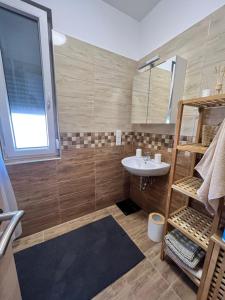 La petite salle de bains est pourvue d'un lavabo et d'un miroir. dans l'établissement Edmond Apartment, à Hévíz