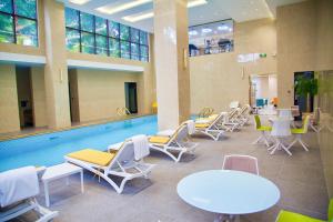 a pool with lounge chairs and tables and a swimming pool at Hôtel FAMILLE MONDIALE in Abidjan