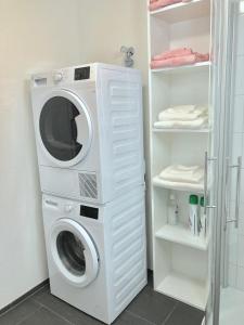 Waschmaschine und Trockner in einer Waschküche in der Unterkunft Gemuetliche 2 Zimmer Wohnung mit Gartensitzplatz in Fällanden