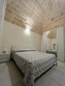 a bedroom with a bed and a stone wall at Donna Maria Pina in Monopoli