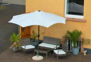 a bench with an umbrella in front of a building at Gästehaus am Viehmarkt in Hillesheim