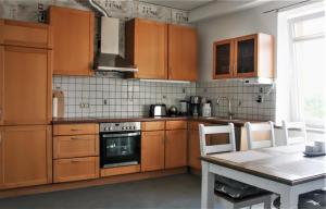 a kitchen with wooden cabinets and a table with chairs at Gästehaus am Viehmarkt in Hillesheim