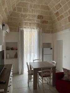 a kitchen with a table and chairs in a room at Donna Maria Pina in Monopoli