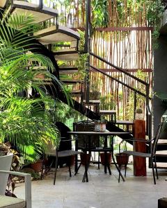 una mesa y sillas en un jardín con una escalera de caracol en Villa 38, en Playa del Carmen
