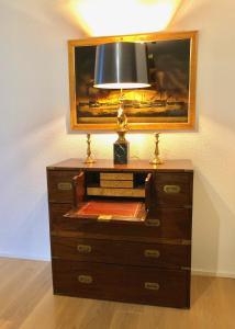 a dresser with a lamp on top of it at Gemuetliche 2 Zimmer Wohnung mit Gartensitzplatz in Fällanden