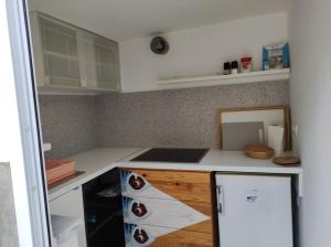 eine Küche mit weißen Arbeitsflächen und einem weißen Kühlschrank in der Unterkunft Holiday Home Paradizo in Veli Lošinj
