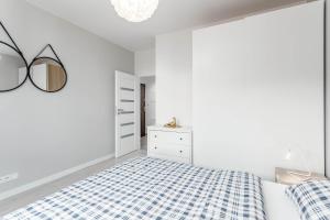 biała sypialnia z niebiesko-białym łóżkiem w kolorze w obiekcie Chill Apartments Ursus w Warszawie
