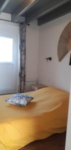 sypialnia z dużym żółtym łóżkiem i oknem w obiekcie Chez Maria w mieście Cherrueix