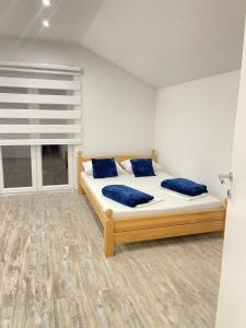Un dormitorio con una cama con almohadas azules y una ventana en Una Bihac 4, en Bihać