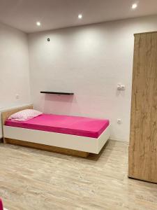 1 dormitorio con 1 cama grande con sábanas rosas en Una Bihac 4, en Bihać