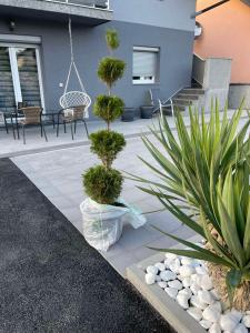 een patio met 2 potplanten en een schommel bij Una Bihac 4 in Bihać