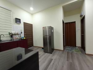 eine Küche mit einem Kühlschrank aus Edelstahl in einem Zimmer in der Unterkunft Fadli HOMESTAY in Kota Bharu