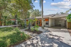 a house with a palm tree in front of it at Sapphire Shores - Sarasota Bungalow w/ Heated Pool and Backyard Oasis in Sarasota