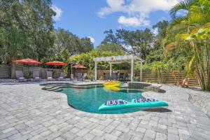 a swimming pool with two rafts in the middle at Sapphire Shores - Sarasota Bungalow w/ Heated Pool and Backyard Oasis in Sarasota