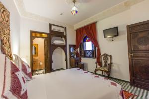 a bedroom with a large white bed and a window at Dar Fes Medina Ziat in Fez