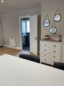 una stanza con un tavolo bianco e due specchi di The Woodside Snug, Eastwell, Vale of Belvoir 