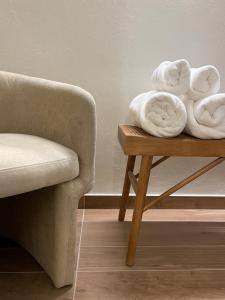 um quarto com um sofá e toalhas numa mesa em Raha Suites em Siracusa