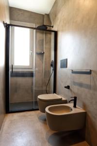 a bathroom with a shower and a toilet and a sink at Mazzini Accommodation in Favignana