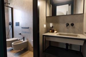 łazienka z umywalką, toaletą i lustrem w obiekcie Mazzini Accommodation w mieście Favignana