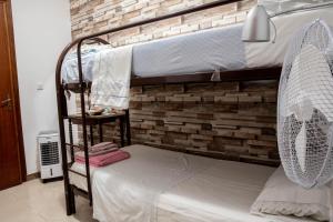 1 dormitorio con 2 literas y pared de ladrillo en B&B Chiaro di Luna en Corleone