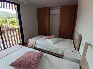 um quarto com 2 camas e uma varanda em Casa João Eusébio 2 em Ponte de Lima