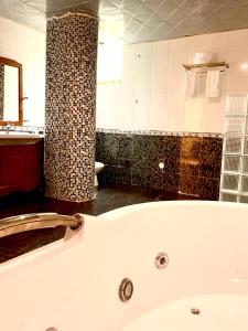 a white bath tub in a bathroom with a sink at De Leopol Hotel in Addis Ababa